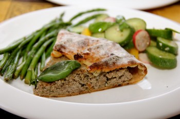 A slice of Open Face Lamb Pie with asparagus and cucumber salad