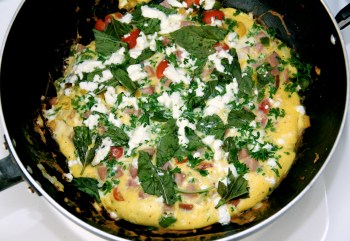 Ham omelette with vegetables, feta and fresh herbs