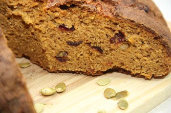 A close up of a roasted pumpkin sourdough with cranberries and pumpkin seed