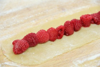 Arranging a single row of berries on the strip of dough