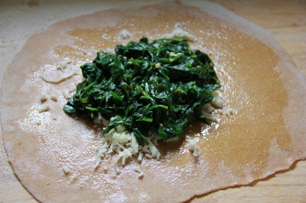 Filling the plăcintă pie with cheese and spinach